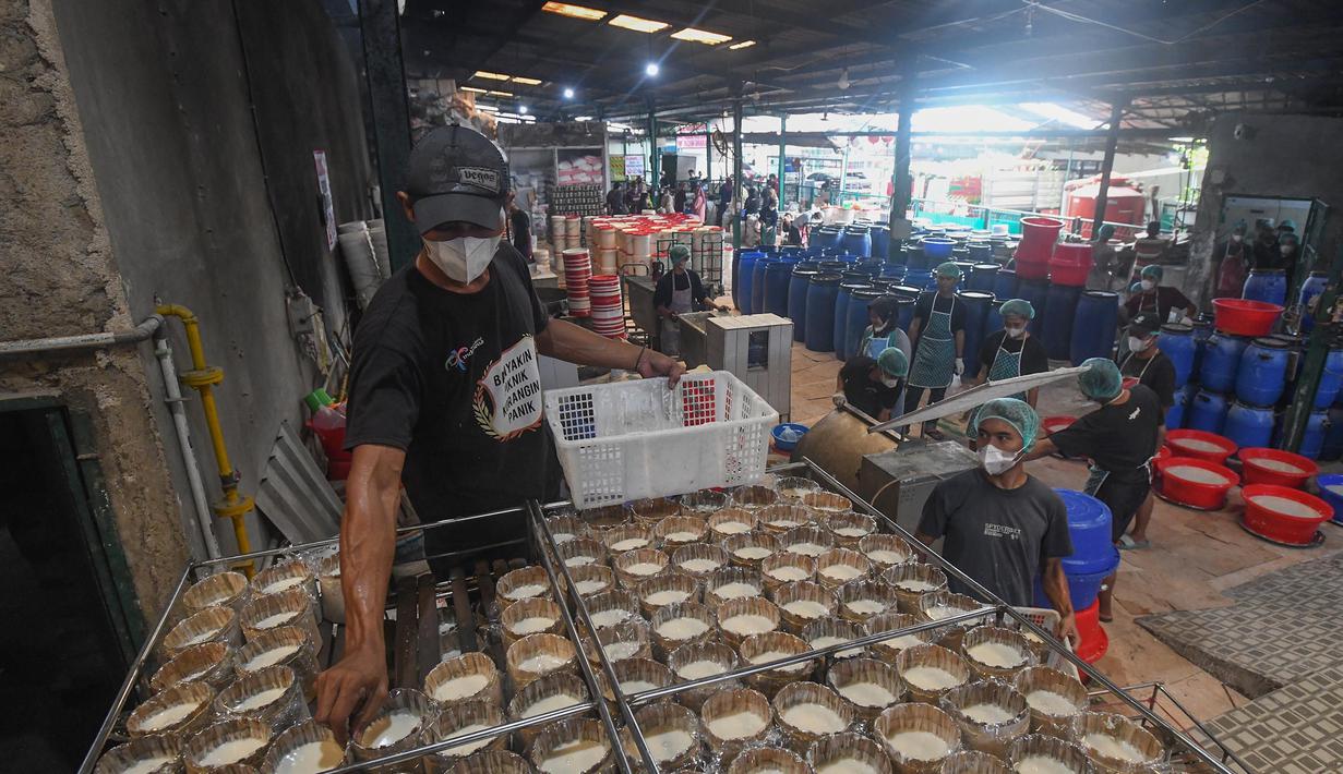 Pekerja menyelesaikan pembuatan kue keranjang di Pabrik Kue Hoki di kawasan Sawangan, Depok, Jawa Barat, Selasa (21/1/2025). (merdeka.com/Arie Basuki)