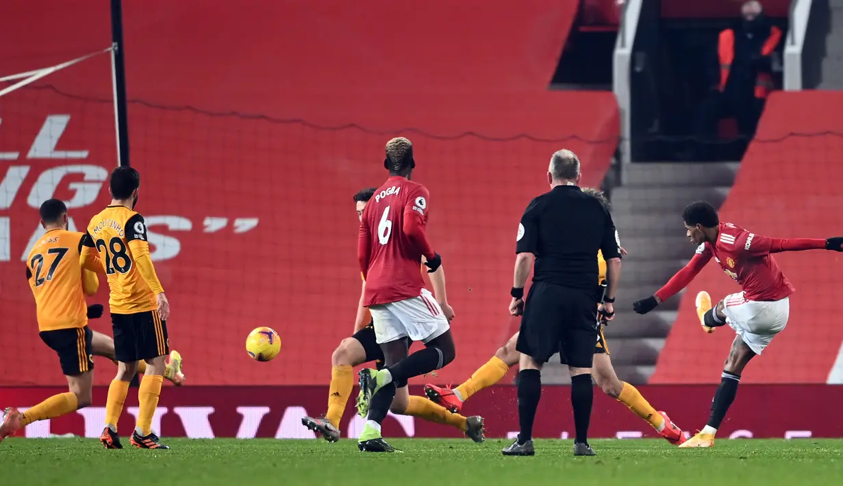 Striker Manchester United, Marcus Rashford (kanan) melepaskan tendangan yang berbuah gol ke gawang Wolverhampton Wanderers dalam laga lanjutan Liga Inggris 2020/21 pekan ke-16 di Old Trafford, Selasa (29/12/2020). Manchester United menang 1-0 atas Wolverhampton. (AFP/Laurence Griffiths/Pool)