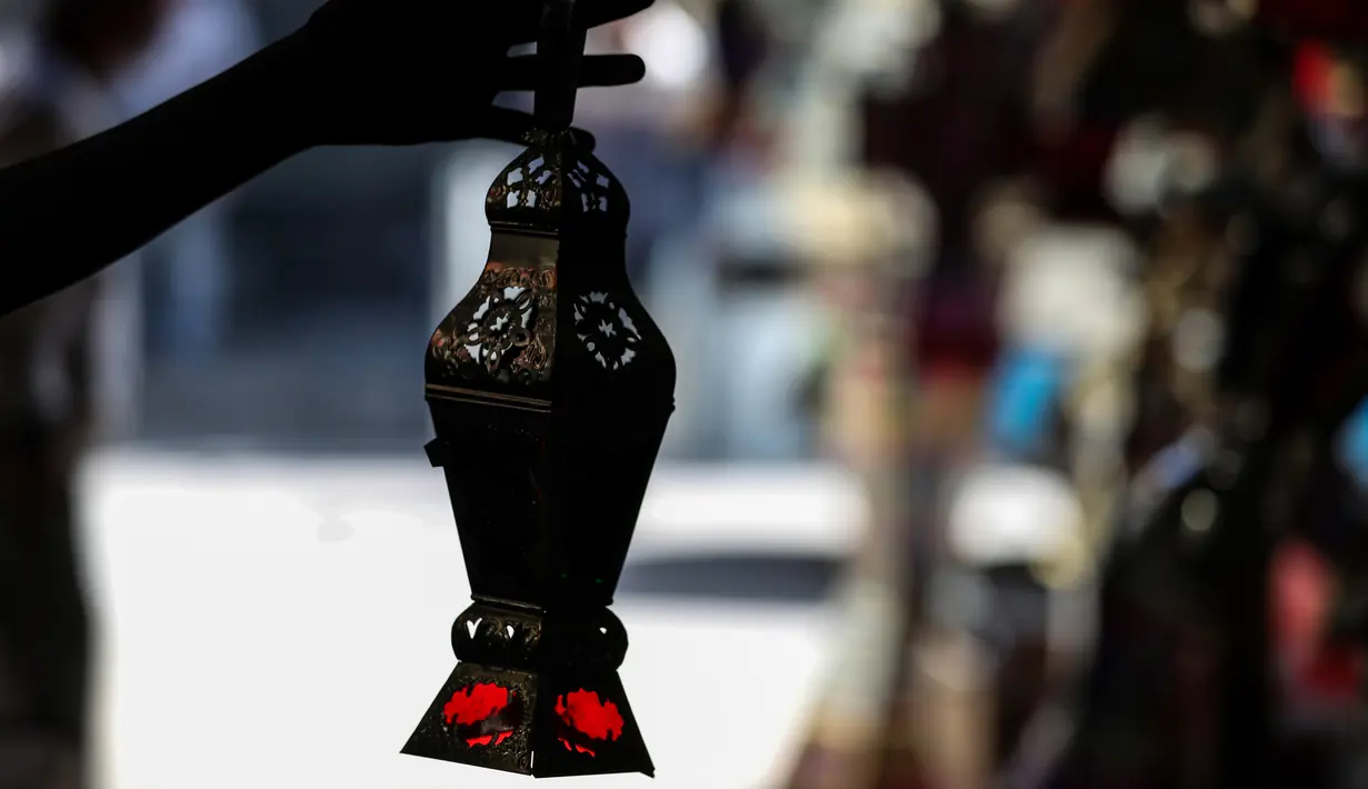 Pria Mesir memegang lentera tradisional yang dikenal dalam bahasa Arab sebagai "Fanous" yang dijual selama bulan suci Ramadan di Sayeda Zainab, Kairo, 19 April 2020.  Menjelang Ramadan 1441 H, warga Mesir mulai berburu lentera warna-warni di tengah pandemi corona Covid-19. (Mohamed el-Shahed/AFP)