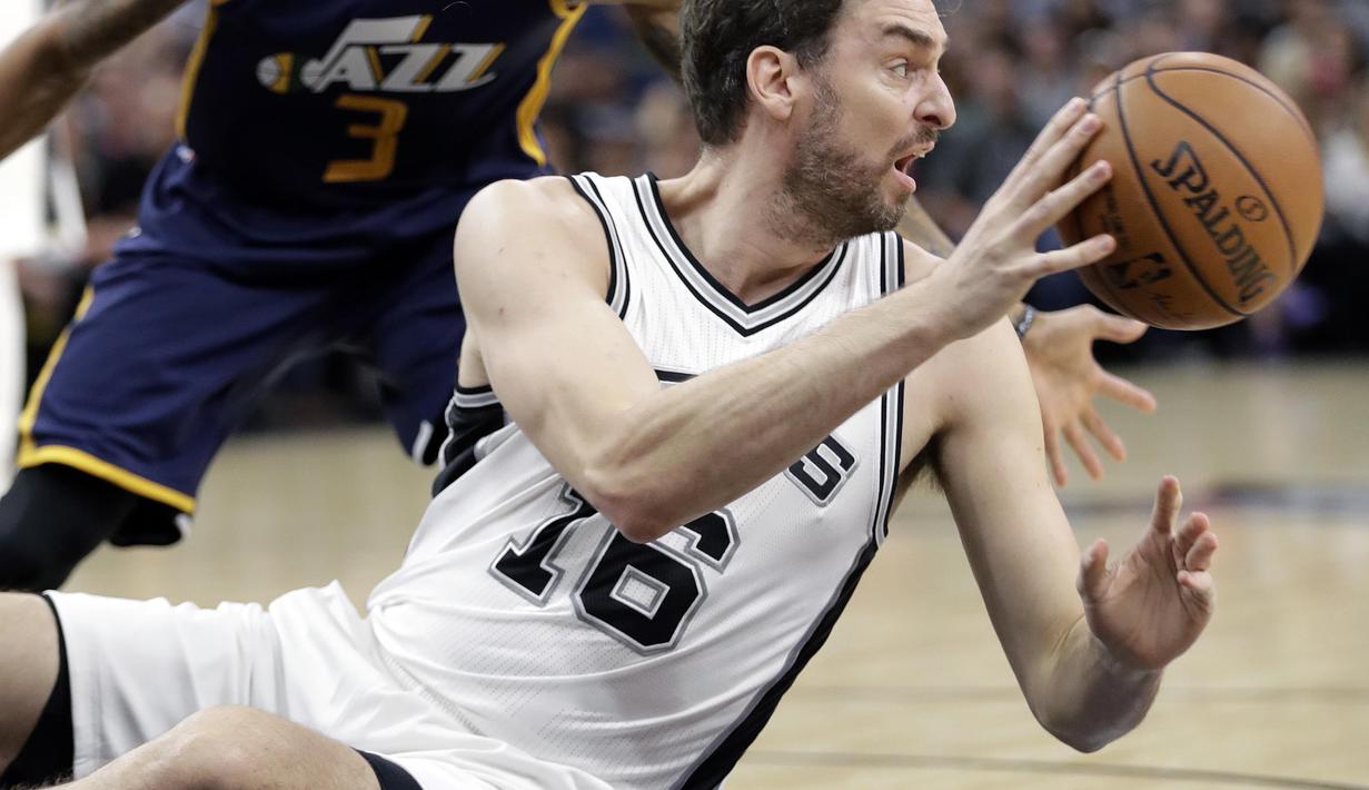 Aksi pemain San Antonio Spurs, Pau Gasol #16 mengamankan bola dari kejaran pemain Utah Jazz,  George Hill #3 pada laga NBA basketball game di AT&T Center, San Antonio, (1/10/2016). Utah menang 106-91. (AP/Eric Gay)