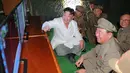 Pemimpin Korut, Kim Jong-un bersama pasukannya melihat monitor saat tes tembakan rudal balistik dari kapal selam, Pyongyang (25/8). Peluncuran rudal disinyalir sebagai bentuk protes atas latihan militer gabungan Korsel-AS. (REUTERS/KCNA)