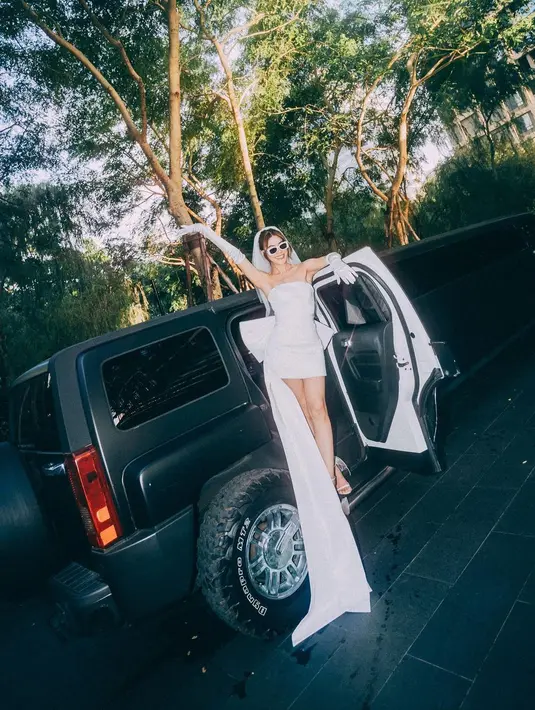 Kimberley adakan pesta lajang mengenakan strapless mini dress dengan tail yang panjang. Kim lengkapi outfitnya dengan gloves panjang dan veil mini [@kimmy_kimberley]