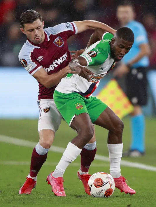Bek West Ham United Aaron Cresswell berebut bola dengan penyerang Rapid Wina, Kelvin Arase pada matchday kedua Grup H Liga Europa 2021/22 di London Stadium, Jumat (1/10/2021) dini hari WIB. West Ham berhasil bermain gemilang dengan memenangkan pertandingan dengan skor 2-0. (AP Photo/Ian Walton)