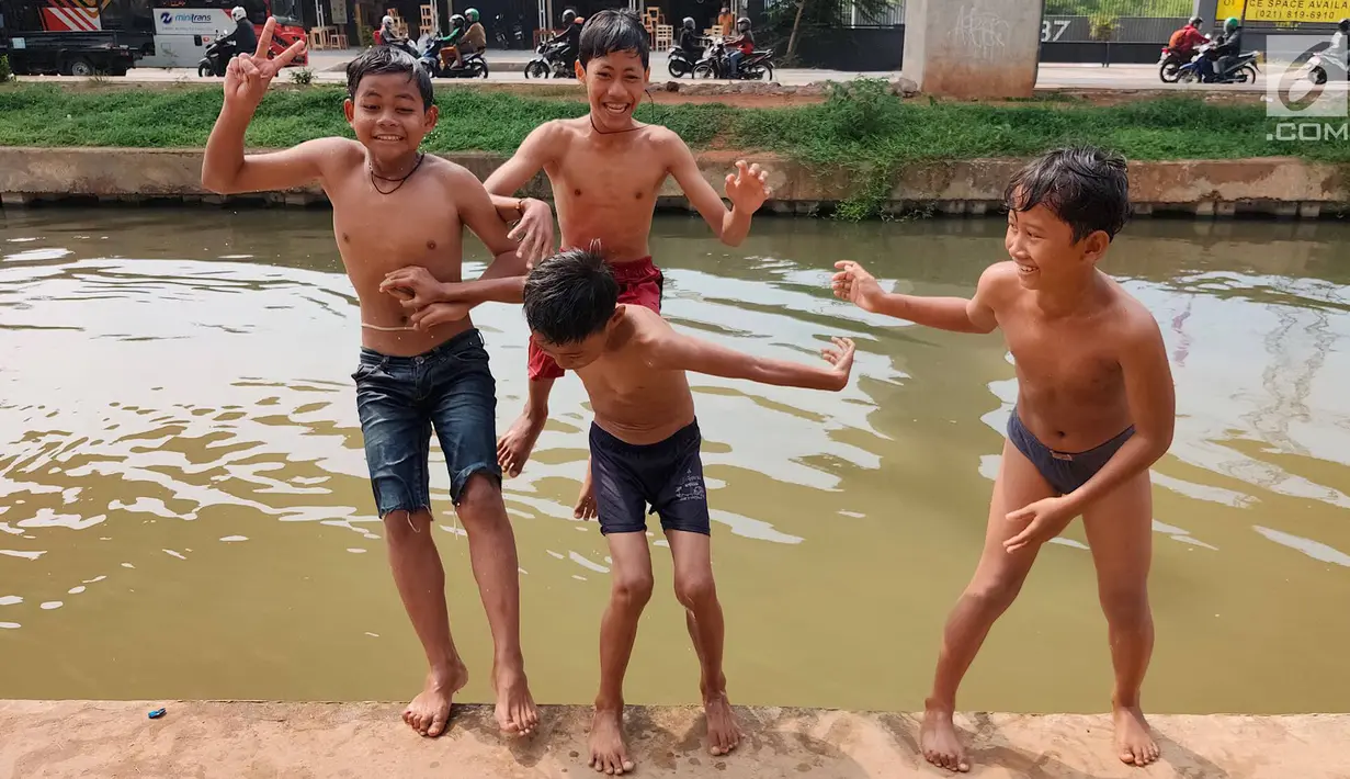 Anak-anak bermain dan berenang di Sungai Kalimalang, Jakarta Timur, Jumat (5/7/2019). Tingginya suhu udara Ibu Kota akibat musim kemarau menyebabkan anak-anak tersebut berenang di Sungai Kalimalang meski dengan kondisi seadanya. (Liputan6.com/Immanuel Antonius)