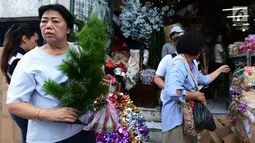 Pembeli memilih pernak-pernik perayaan Natal di Pasar Asemka, Jakarta,Kamis (13/12). Pedagang mengaku penjualan pernak-pernik Natal meningkat dari minggu sebeumnya. (Merdeka.com/Imam Buhori)