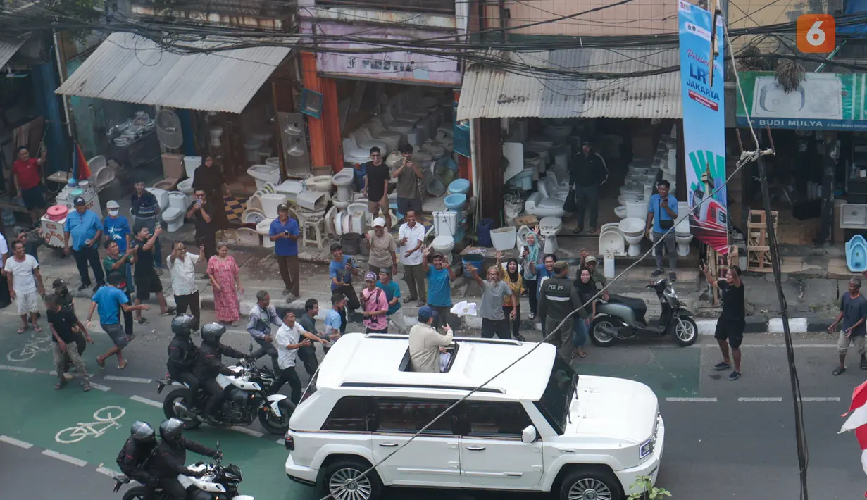 Presiden Prabowo Subianto membagikan kaus kepada warga dari dalam kendaraan Maung saat melintas di Jalan Minangkabau, Jakarta, Rabu (16/9/2026). Aksi tersebut berlangsung setelah Prabowo menyapa warga di sekitar Stasiun LRT Manggarai. (KLY/Budy Santoso)