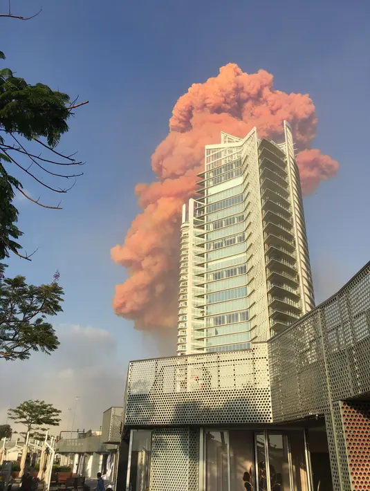 Sebuah foto yang diambil dari Teluk Zaytouna menunjukkan gumpalan api merah di belakang sebuah bangunan tinggi di pusat kota Beirut tepat setelah ledakan besar mengguncang ibukota Lebanon (4/8/2020). (AFP Photo/Bassem El Hage)