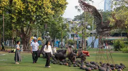 Pengunjung mengamati karya dalam pameran seni rupa kontemporer luar ruang Jakarta Provoke! di Taman Menteng, Jakarta Pusat, Jumat (17/7/2026). Pameran gratis yang berlangsung hingga 26 Juli 2026 ini menghadirkan 25 karya dari 25 seniman dan kolektif tentang dinamika kehidupan Jakarta. (KLY/Budy Santoso)