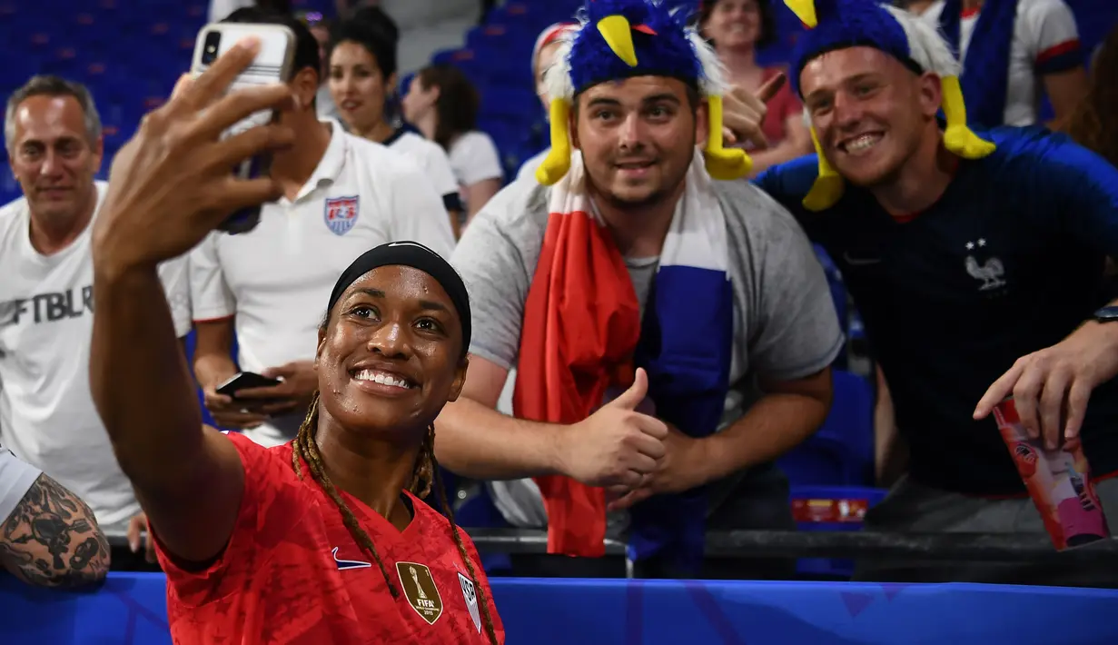 United States' forward Jessica McDonald takes a selfie with supporters  after  the France 2019 Women's World Cup semi-final football match between England and USA, on July 2, 2019, at the Lyon Satdium in Decines-Charpieu, central-eastern France. (Photo by FRANCK FIFE / AFP)