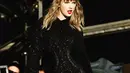 Mengenakan bodysuit lengan panjang berwarna hitam, Taylor Swift berjalan dengan penuh energi di tengah panggung. Ia pun menambah korset di bagian pinggang untuk memperkuat fitur lekuk pinggangnya. Outfit ini makin terlihat seksi dengan high boots.