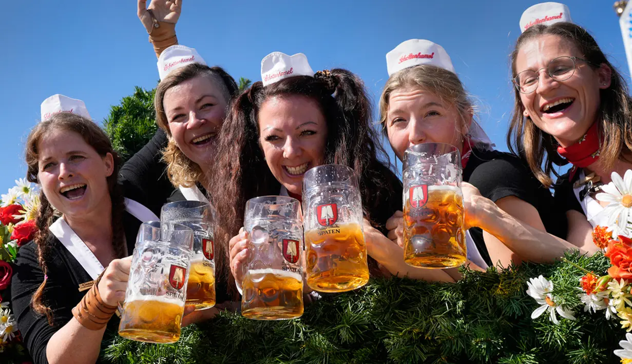 Para wanita memegang gelas berisi bir saat festival bir 'Oktoberfest' ke-188 di Munich, Jerman, Sabtu (16/9/2023). Aliran bir dan kerumunan orang berdatangan ke Munich untuk menyambut dimulainya Oktoberfest secara resmi. (AP Photo/Matthias Schrader)