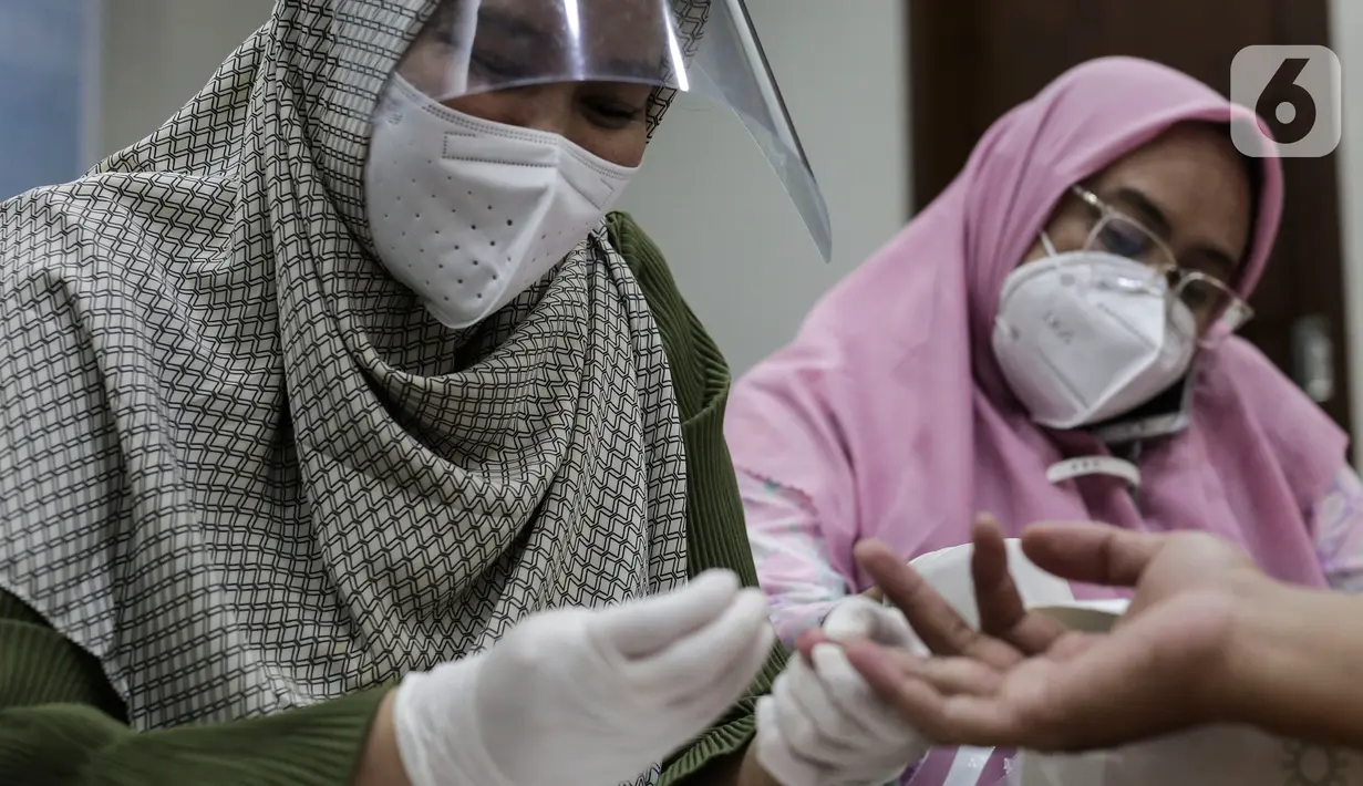 Petugas medis mengambil sampel darah wartawan yang bertugas di DPR saat rapid test di Ruang Wartawan, Kompleks Parlemen, Senayan, Jakarta, Rabu (1/7/2020). Rapid test yang digelar secara gratis ini untuk mendeteksi penyebaran dan memutus mata rantai Penyebaran Covid 19. (Liputan6.com/Johan Tallo)