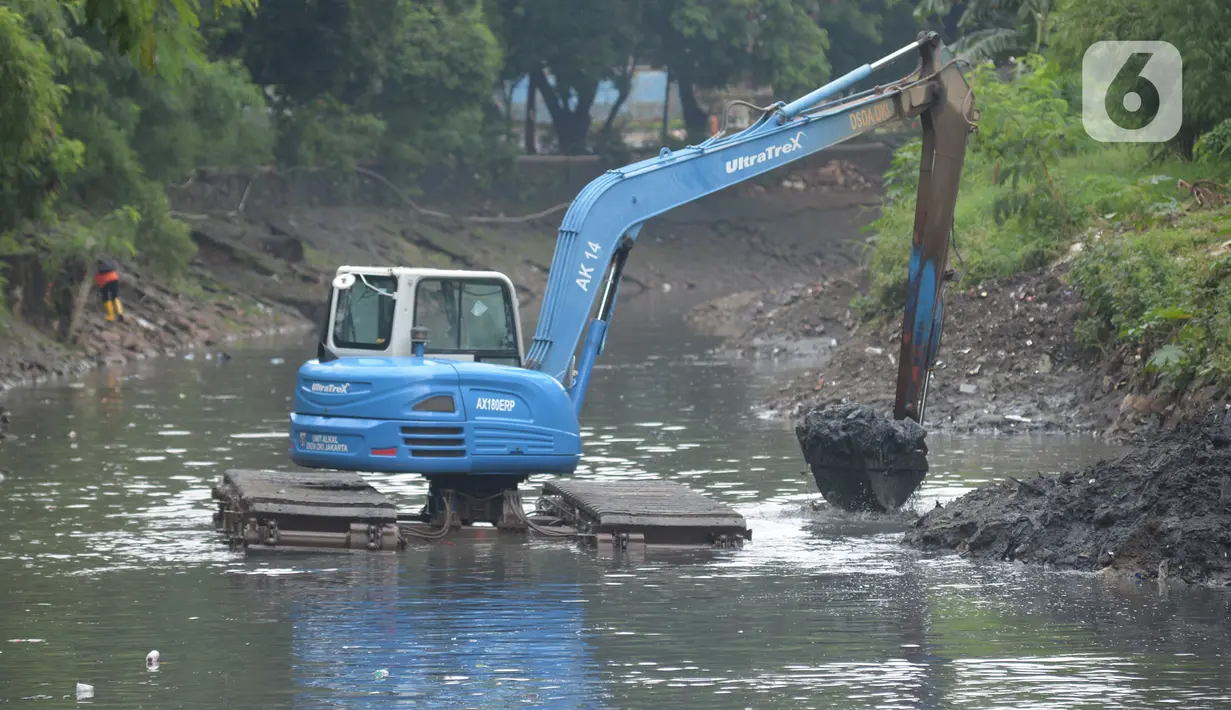 Sebuah alat berat mengeruk lumpur excavator mengeruk material endapan lumpur di kanal sungai perkantoran Kuningan Jakarta, Rabu (17/2/2021). Pengerukan dilakukan untuk memperlancar aliran air agar tidak terjadi pendangkalan yang mengakibatkan genangan air. (merdeka.com/Imam Buhori)