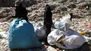 Seorang wanita bersama anaknya mencari sampah di sebuah tempat pembuangan akhir (TPA) di pinggiran Sanaa, Yaman, Rabu (16/11). Setiap hari para bocah di daerah tersebut mengumpulkan sampah untuk didaur ulang atau dijual. (REUTERS/Mohamed al-Sayaghi)