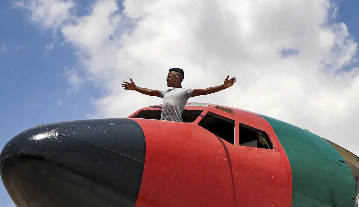 Seorang pemuda berdiri melalui kanopi kosong pesawat Boeing 707 yang diubah oleh saudara kembar Palestina Atallah dan Khamis al-Sairafi menjadi sebuah restoran di kota Nablus, pada 5 Juli 2021. Restoran bertema penerbangan itu dihiasi dengan bendera Palestina dan Yordania (JAAFAR ASHTIYEH/AFP)
