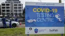 Staf memeriksa klien di klinik pengujian COVID-19 drive-thru di Pantai Bondi di Sydney, Sabtu (8/1/2022). Negara bagian terpadat di Australia itu memberlakukan kembali beberapa pembatasan dan menangguhkan operasi elektif ketika kasus COVID-19 melonjak ke rekor baru lainnya. (AP Photo/Mark Baker)