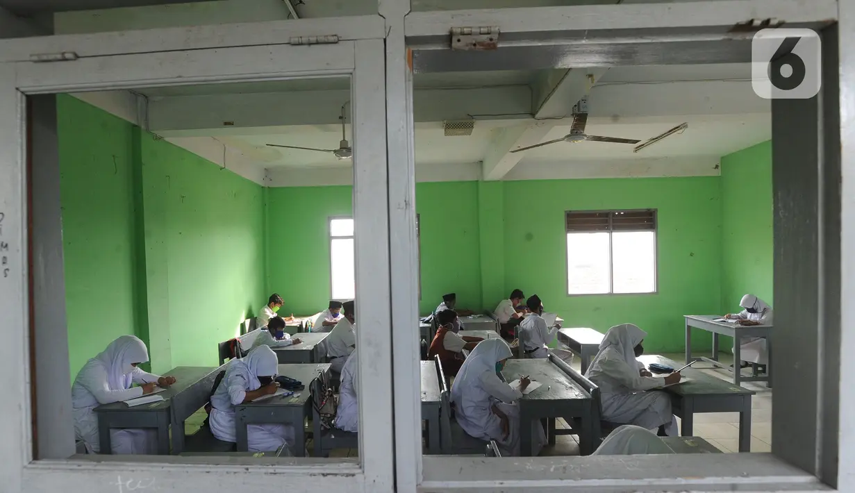 Murid baru menggunakan masker  mengikuti tes penentuan kelas tahun ajaran 2020-2021 yang selanjutnya akan mengikuti kegiatan belajar mengajar (KBM) secara darling di MTs Hidayatul Umami, Cinere, Depok, Jawa Barat, Senin (13/7/2020). (merdeka.com/Arie Basuk)