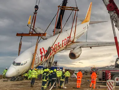 Sebuah crane mengangkat pesawat Boeing 737-800 dari maskapai Pegasus Airlines yang nyaris terperosok ke dalam laut di bandara Trabzon, Turki (18/1). Sebelumnya, pesawat itu tergelincir dari landasan pacu. (AP Photo / Turkay Albayak)