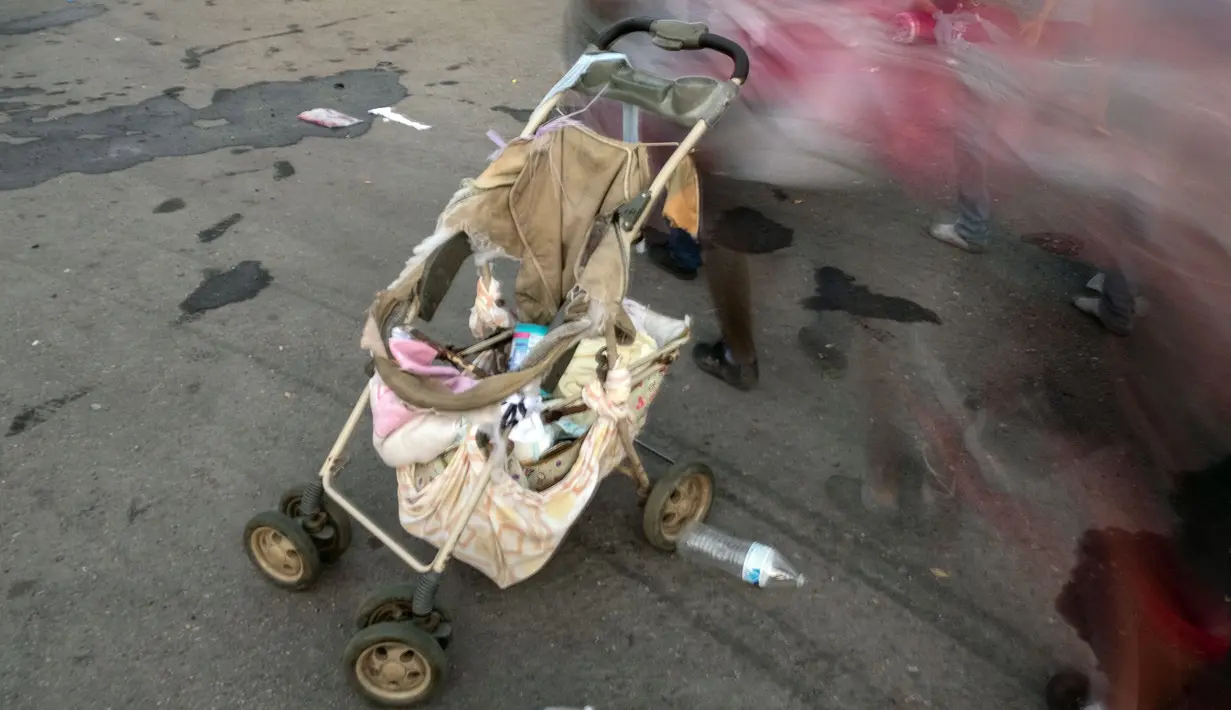 Imigran yang sebagian besar penduduk Honduras melewati kereta bayi yang rusak dalam perjalanan menuju AS di Pijijiapan, Meksiko, 26 Oktober 2018. Kereta dorong bayi telah menjadi barang mewah bagi para imigran dalam perjalanan mereka (Guillermo Arias/AFP)