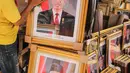 Pedagang merapikan bingkai foto Presiden Joko Widodo dan Wakil Presiden terpilih Ma'ruf Amin yang dijualnya di Pasar Baru, Jakarta, Rabu (16/10/2019). Menjelang pelantikan presiden, foto pasangan Jokowi-Ma'ruf Amin mulaih dijual ke pasar umum. (Liputan6.com/Faizal Fanani)
