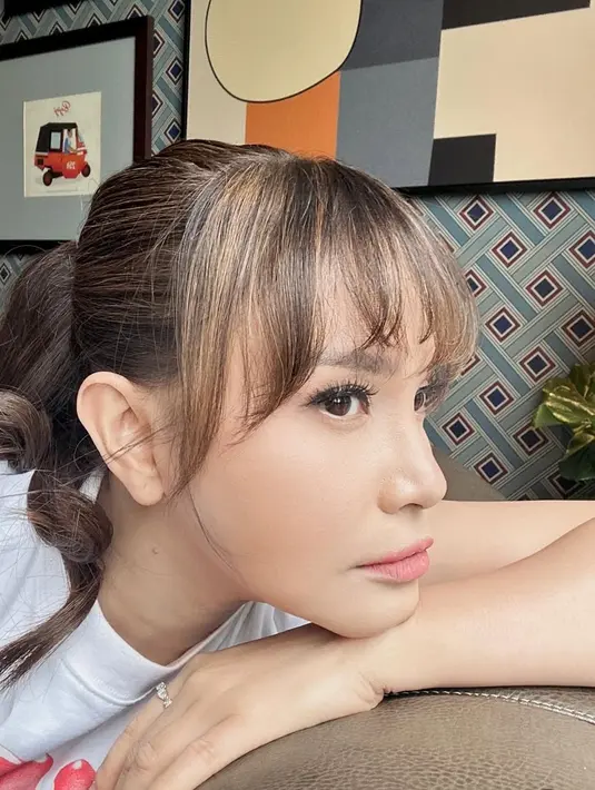 <p>Rambut ke coklat nya tampak diikat ke belakang ponytail dengan gaya curly. Yang tampak berbeda ialah poni nya. [@itsrossa910]</p>