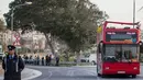 Petugas kepolisian berdiri dekat sebuah bus tingkat beratap terbuka yang menabrak dahan pohon di Zurrieq, Malta, Senin (9/4). Kejadian ini mengakibatkan dua orang tewas dan puluhan penumpang lainnya termasuk anak-anak terluka. (AP Photo/Rene Rossignaud)