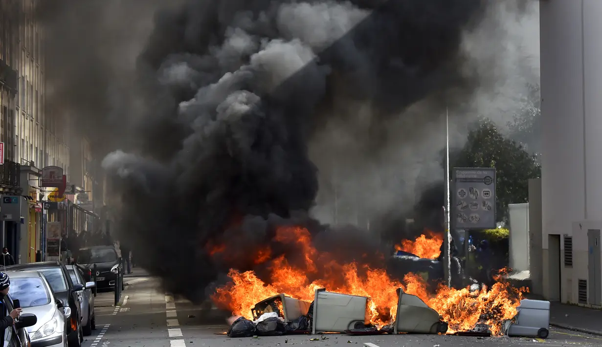 Aksi bakar kaleng mewarnai unjuk rasa yang digelar mahasiswa dan pekerja di Nantes, Prancis bagian barat, Kamis Mereka menolak rancangan undang-undang sosialis pemerintah Prancis yang dinilai merugikan pekerja. (Loic VENANCE/AFP)