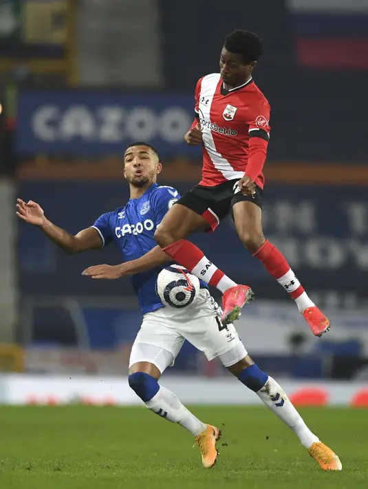 Gelandang Everton, Mason Holgate berebut bola dengan pemain Southampton, Nathan Tella pada pertandingan lanjutan Liga Inggris di Goodison Park di Liverpool, Inggris, Selasa (2/3/2021). Tambahan tiga poin membuat Everton  menempel rival sekota Liverpool. (Gareth Copley/Pool via AP)