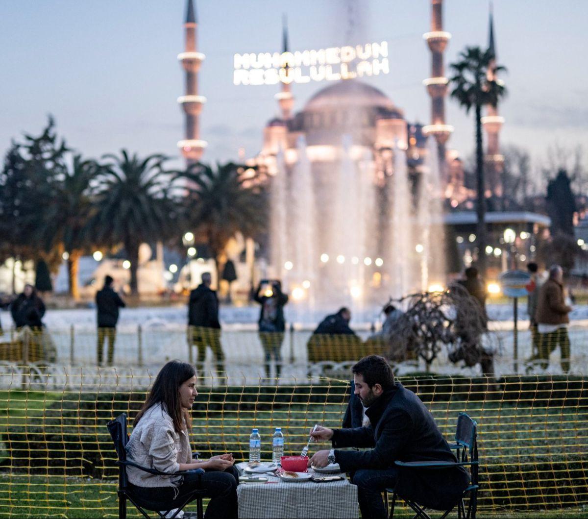 Sepasang suami istri berbagi makanan berbuka dengan latar belakang Masjid Biru di Alun-Alun Sultan Ahmed, Istanbul, Turki, pada hari pertama Ramadan, Senin (11/3/2024).&nbsp;Kota Istanbul di Turki menawarkan suasana Ramadan yang sangat unik.&nbsp;Yasin Ak