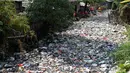 Petugas kebersihan membersihkan sampah di Kali Bahagia, Bekasi, Jawa Barat, Kamis (1/8/2019). Sampah di Kali Bahagia semakin menumpuk hingga menyerupai daratan. (AP Photo/Tatan Syuflana)