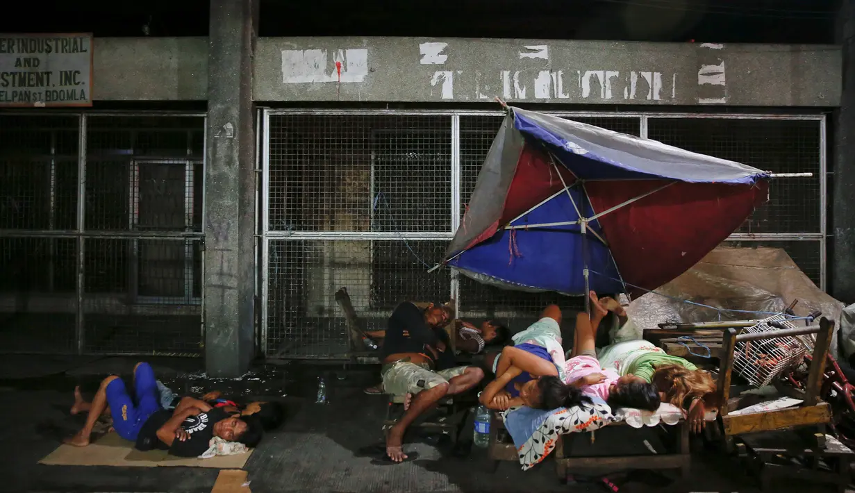 Sejumlah warga tidur di pinggir jalan di kawasan Tondo, Manila, Selasa (18/10). Banyak warga Filipina memilih tidur di jalan dan meninggalkan rumah mereka karena khawatir menjadi sasaran terkait operasi anti-narkoba Duterte. (REUTERS/Damir Sagolj)