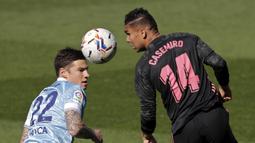 Gelandang Real Madrid, Casemiro (kanan) menyundul bola dari ancaman striker Celta Vigo, Santi Mina dalam laga lanjutan Liga Spanyol 2020/2021 pekan ke-28 di Balaidos Stadium, Sabtu (20/3/2021). Real Madrid menang 3-1 atas Celta Vigo. (AP/Lalo R. Villar)