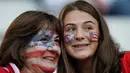 Dua fans wanita AS tersenyum sebelum pertandingan Grup F Piala Dunia Wanita 2019 antara Amerika Serikat melawan Thailand di Stadion Auguste-Delaune di Reims, Prancis (11/6/2019). (AFP Photo/Lionel Bonaventure)