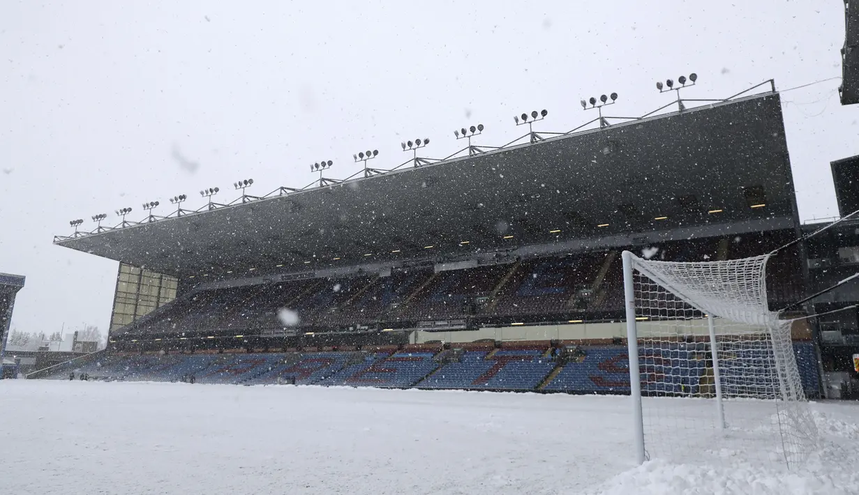 Pemandangan salju di lapangan saat pertandingan antara Burnley dan Tottenham Hotspur ditunda di Turf Moor, Inggris, Minggu (28/11/2021). Meskipun upaya membersihkan lapangan sudah dikerahkan, laga Burnley dan Tottenham akhirnya diputuskan ditunda. (Bradley Collyer/PA via AP)