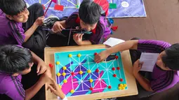 Festival ini digelar sebagai upaya menghidupkan kembali tradisi bermain di tengah kuatnya pengaruh digital pada anak-anak Indonesia. Tampak dalam foto, anak-anak mencoba permainan tradisional di acara Teras Main Indonesia 2025 di Taman Mini Indonesia Indah (TMII), Jakarta, Sabtu (15/11/2025). (merdeka.com/Arie Basuki)