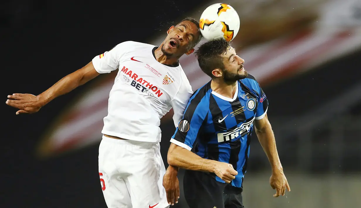 Gelandang Sevilla, Fernando melompat saat berebut bola dengan pemain Inter Milan, Roberto Gagliardini pada pertandingan Final Liga Europa di Stadion Rhein Energie, Sabtu (22/8/2020) dini hari. Sevilla menjadi juara Liga Europa setelah menang dengan skor 3-2. (Lars Baron, Pool Photo via AP)