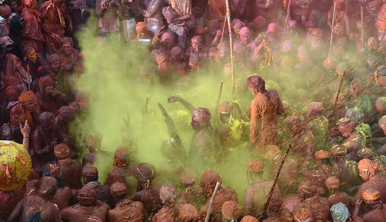Sejumlah warga India merayakan festival Holi di desa Nandgaon di negara bagian Uttar Pradesh, India (7/3). Holi dirayakan secara besar-besaran di tempat-tempat yang berkaitan dengan Sri Kresna seperti Mathura, Vrindavan, Nandagaon, dan Barsana. (AFP)