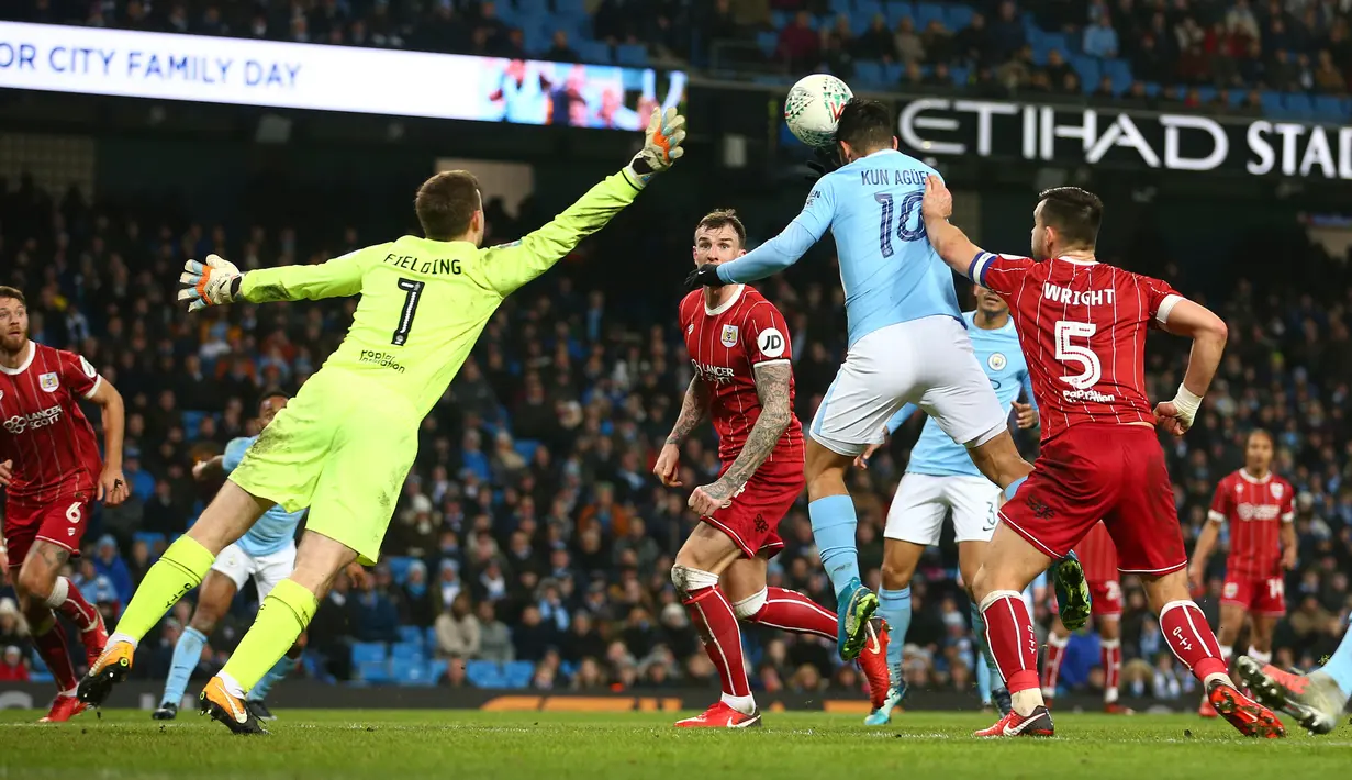 Pemain Manchester City, Sergio Aguero mencetak gol ke gawang Bristol City pada leg pertama semifinal Piala Liga Inggris di Stadion Etihad, Selasa (9/1). Tertinggal lebih dulu, City akhirnya menang 2-1 berkat gol Aguero di injury time. (AP/Dave Thompson)
