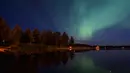 Langit desa Erikslund  berhias cahaya aurora borealis, di Swedia, (23/8). Fenomena langka ini muncul dari tabrakan antara partikel gas di atmosfer bumi dengan partikel bermuatan dari matahari. (AFP PHOTO/ JONATHAN NACKSTRAND)