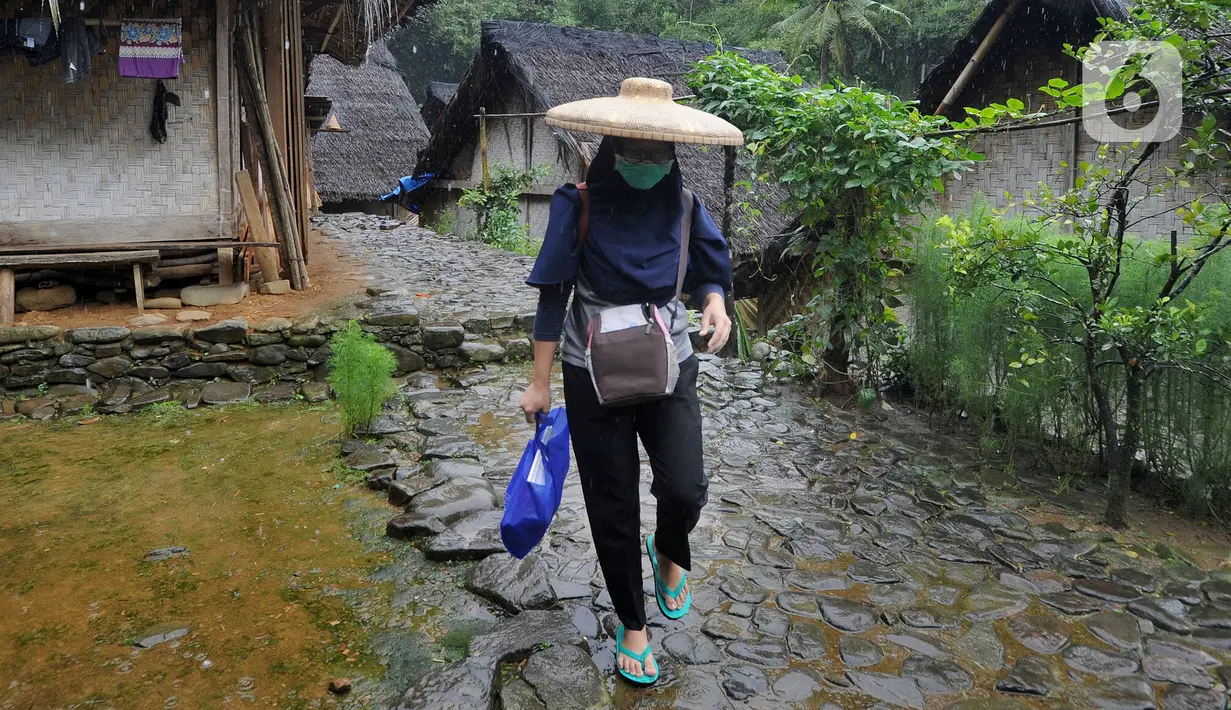 Petugas medis Puskesmas Cisimeut Bidan Pite saat kegiatan Posyandu keliling di Kampung Baduy Luar Gazebo, Kanekes, Banten, Rabu (27/01/2021). Setiap bulannya ia berkeliling Baduy Luar untuk memberikan pelayanan kesehatan bagi puluhan  ibu hamil dan balita warga. (merdeka.com/Arie Basuki)