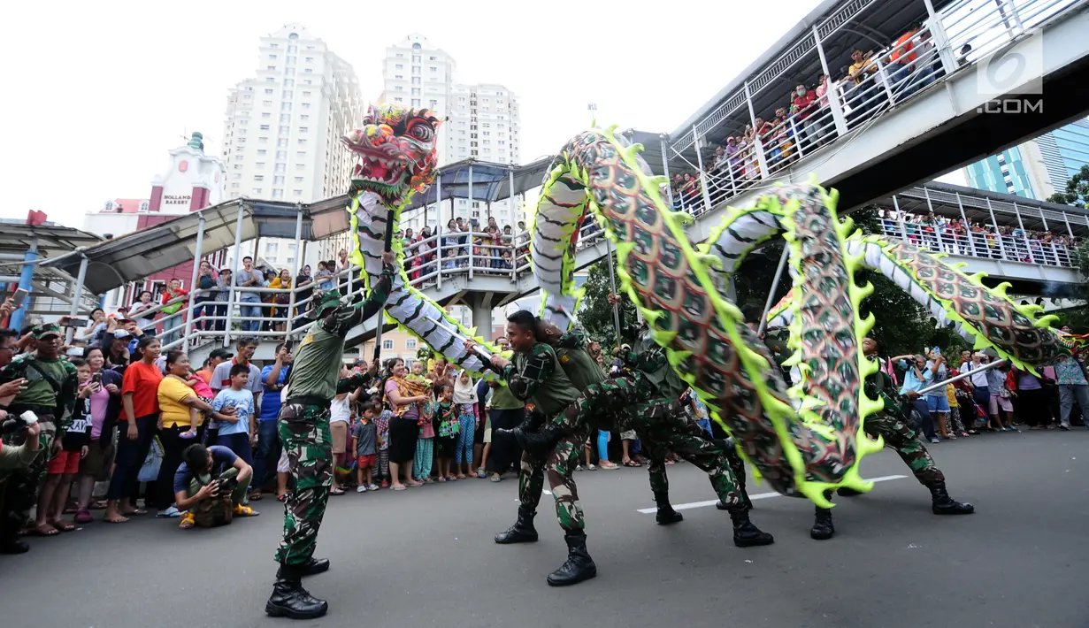 Anggota TNI memainkan atraksi liong saat karnaval Cap Go Meh 2018 di Jalan Gajah Mada, Jakarta, Minggu (4/3). Beragam atraksi budaya ditampilkan dalam karnaval perayaan Cap Go Meh 2018 di kawasan Glodok Jakarta. (Liputan6.com/Helmi Fithriansyah)