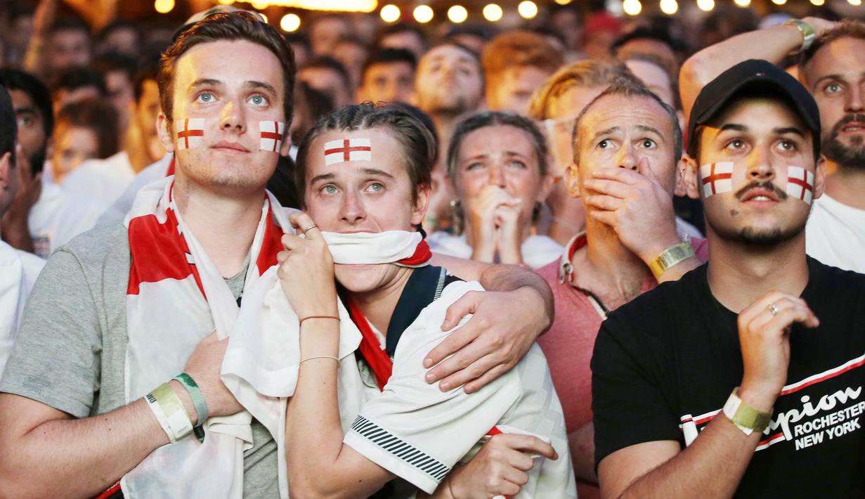 Sejumlah fans tampak kecewa saat timnas Inggris gagal melaju ke final Piala Dunia di Flat Iron Square, london, Rabu (11/7/2018). Kroasia menang 2-1 atas Inggris. (AP/Luca Bruno)
