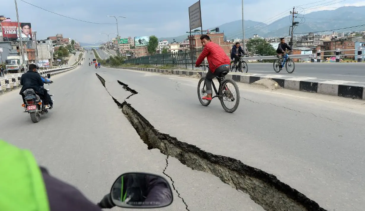 Penampakan jalan di Kathmandu yang rusak parah akibat gempa bumi yang menghantam Nepal, Minggu (26/4/2015). Gempa berkekuatan 7,8 Skala Richter dikabarkan telah menelan korban sekitar 2000 jiwa. (AFP Photo/Prakash Mathema)