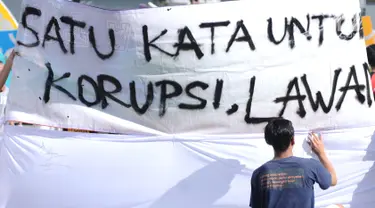 Warga menandatangani spanduk dukungan anti korupsi yang dibentangkan saat Hari Bebas Kendaraan di kawasan Bundaran HI, Jakarta, Minggu (10/12). Aksi dilakukan untuk memperingati Hari Anti-Korupsi Sedunia, 9 Desember. (Liputan6.com/Helmi Fithriansyah)