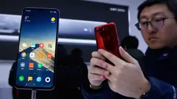 Seorang tamu undangan mencoba smartphone Xiaomi Mi 9 saat peluncuran di Beijing, China, Rabu (20/2). Sesuai rumor yang beredar, Mi 9 merupakan salah satu smartphone pertama yang resmi menggunakan Snapdragon 855. (AP Photo/Andy Wong)