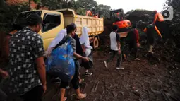 Warga melewati longsor yang menutup ruas jalan utama Cipanas-Cianjur akibat gempa bumi di kawasan Cugenang, Cianjur, Jawa Barat, Senin (21/11/2022). Longsor membawa sebuah angkot yang diduga berisi penumpang dan truk ke dalam jurang, evakuasi pun akan dilanjutkan esok hari. (merdeka.com/Arie Basuki)