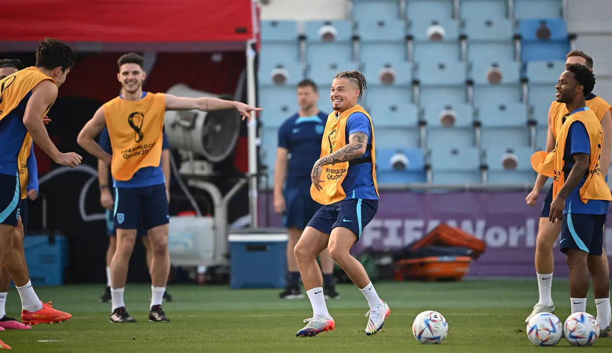 Gelandang Inggris #14 Kalvin Phillips (Tengah) dan rekan satu timnya ambil bagian dalam sesi latihan jelang kontra Prancis pada perempat final Piala Dunia 2022, di Stadion Al Wakrah SC, selatan Doha, Jumat (9/12/2022). Di Piala Dunia 2022, Inggris telah mencetak total 12 gol dalam empat laga. (Paul ELLIS / AFP)