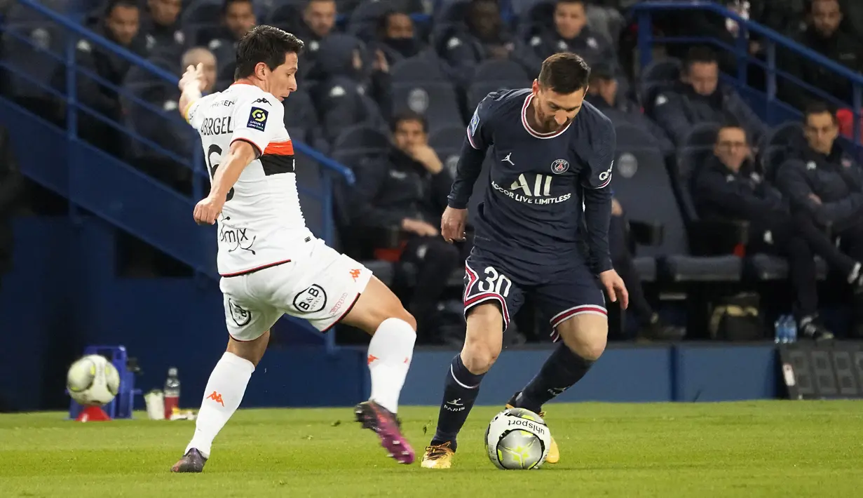 Penyerang PSG, Lionel Messi  berusaha melewati pemain Lorient, Laurent Abergel pada pertandingan lanjutan Liga 1 Prancis di stadion Parc des Princes di Paris, Senin (4/4/2022). PSG menang telak atas Lorient 5-1. (AP Photo/Michel Euler)