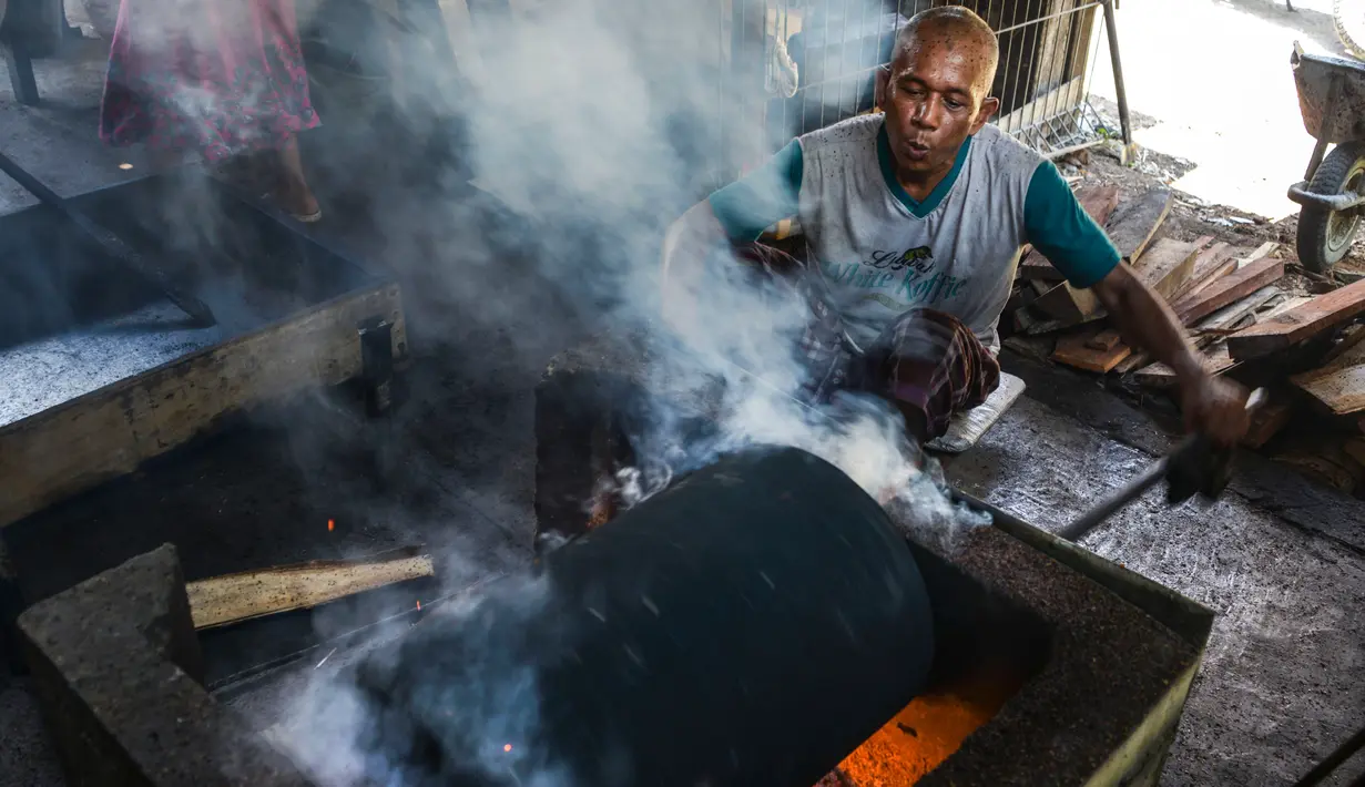 Pekerja memanggang biji kopi melalui metode tradisional di sebuah pabrik di Banda Aceh, Aceh, Rabu (3/3). (CHAIDEER MAHYUDDIN/AFP)