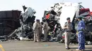 Petugas berada di lokasi kecelakaan yang melibatkan truk dan bus di jalan raya antara Ibri dan Fahud, Oman bagian barat, Selasa (1/3). Sebanyak 18 orang dari beberapa kewarganegaraan tewas dan 14 lainnya luka-luka. (STRINGER/Omani Police/AFP)